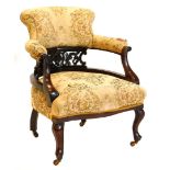 An early 20thC mahogany tub shaped chair, upholstered in tapestry style fabric to the back and seat,
