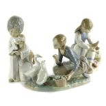 A Lladro porcelain figure of a young girl with two geese, similar Nao figure of a lady seated