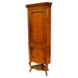A 19thC oak and burr oak standing corner cabinet, with a moulded and dental cornice above a panelled