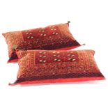 A near pair of large rectangular Belouch carpet cushions, with a design of medallions on a red
