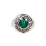 An 18ct white gold oval emerald and diamond cluster ring, set with oval cut emerald 1.70cts,