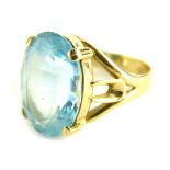 A silver dress ring, set with large blue paste stone, on gold coloured silver band, ring size P.