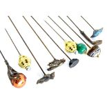 A collection of hat pins, to include a golf club, an Art Nouveau style piece inset with a red