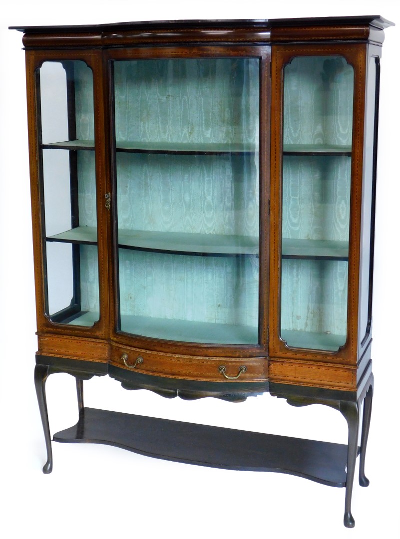 An Edwardian mahogany and checker banded display cabinet, with a shaped top, a bow fronted central