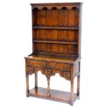 A small oak dresser in 18thC style, the plate rack with a shaped crest above two shelves, the base