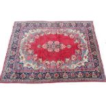 An Eastern carpet, with a central floral medallion, on a red ground with multi-coloured spandrels,