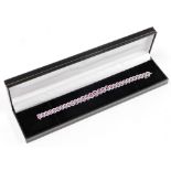 An 18ct white gold pink sapphire and diamond cluster line bracelet, the design with graduated oval