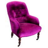 A Victorian mahogany armchair, upholstered in buttoned vivid purple fabric, on turned legs with