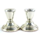 A pair of Elizabeth II silver dwarf candlesticks, each of plain form, with a weighted base,