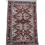 A Persian rug, with design of three X shaped medallions, on a cream ground with one wide and