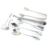 A collection of small silver spoons, sugar tongs, etc., various types, dates, etc., 1½ oz.