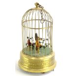 A continental pressed brass three bird musical bird cage, on a circular base (AF), 28cm high.