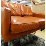 A tan coloured vintage style leather two seater sofa, on square tapering legs, 132cm wide.