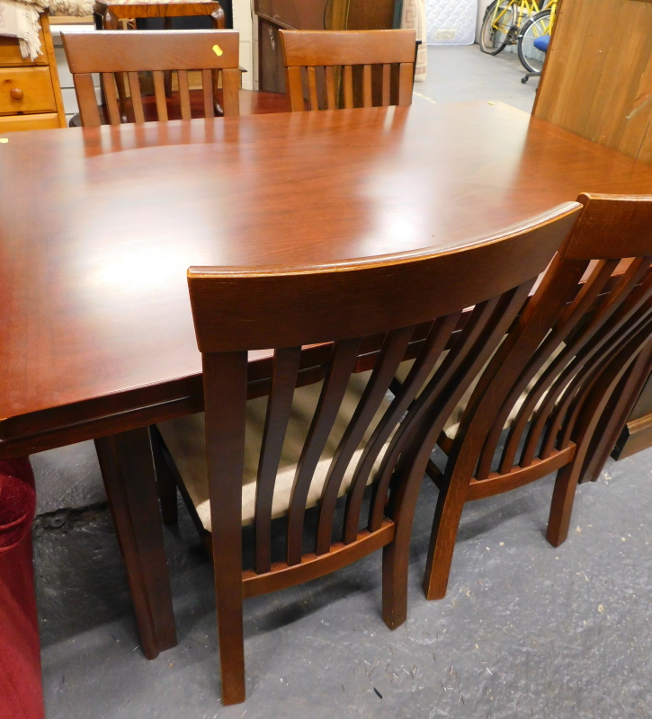 A rectangular topped dining table with four associated chairs.