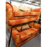 A pair of two seater sofas, in orange and red colour way.