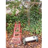 A pair of red painted car ramps, fire grate and a cylinder mower.