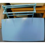 A pale blue painted towel rail, and a kitchen table with blue melamine top.