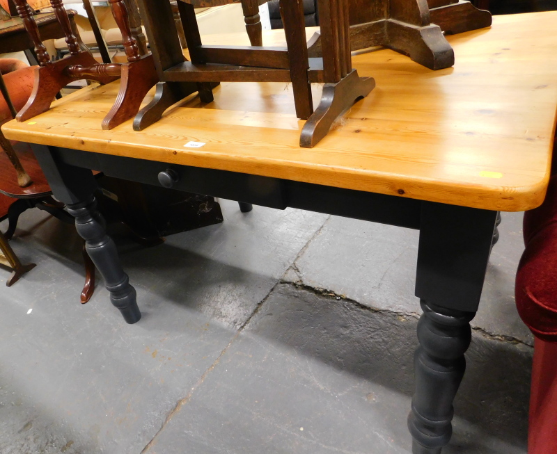 A pine kitchen table, with grey painted base.