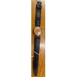 A gentleman's wristwatch, with small circular dial of orange colour, with rubbed markings and