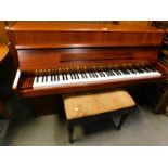 A Fuchs and Mohr upright piano in a teak case and a piano stool, on turned tapering legs.