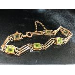 Gold Bracelet marked 15ct with six gold mounted square cut Peridot stones