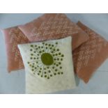 Four modern scatter cushions, three in dusky pink, one in cream/green