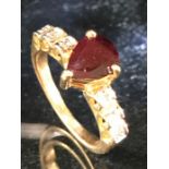 9ct Gold Dress ring with central red faceted stone and CZ stones set to shoulders