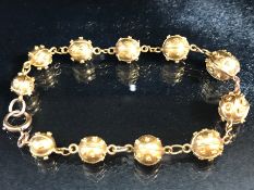 Gold Bracelet of links and graduated studded Gold balls (total weight 13.7g) the clasp marked 9ct,