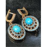 Pair of silver earrings with central panelled turquoise in a halo style