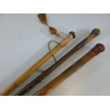 Three rustic wooden walking sticks one with Amber style tassel