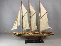 Large wooden scale model of a tall Ship with masts and rigging displayed on a plinth. Length