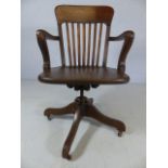 Oak slat-backed captain's chair on castors