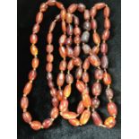 Long string of oval Amber beads knotted and of irregular shapes approx 145cm in total length (A/F)