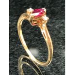 9ct Gold ladies ring with central oval Ruby and flanked by two Diamonds.size N