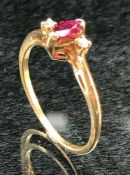 9ct Gold ladies ring with central oval Ruby and flanked by two Diamonds.size N