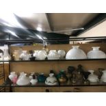 Extensive collection of copper and brass oil lamps, glass shades and chimneys (over two shelves)