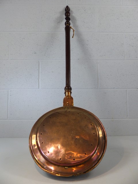 Brass and copper bed pan with incised decoration and turned wooden handle