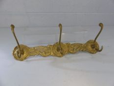 Three brass coat hooks with floral decoration