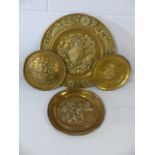 Four brass embossed plates or platters