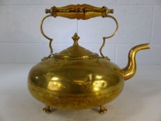 Brass kettle on four brass feet with glass handle