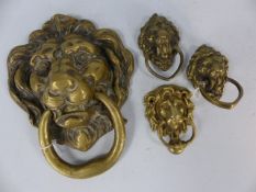 Large brass doorknocker in the shape of a lions head with three additional lions head doorknockers