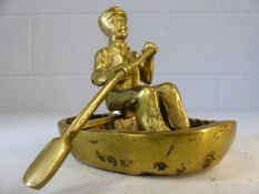 Brass model of man paddling a coracle