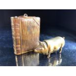 Two brass vesta cases, one in the form of a pig, the other a book