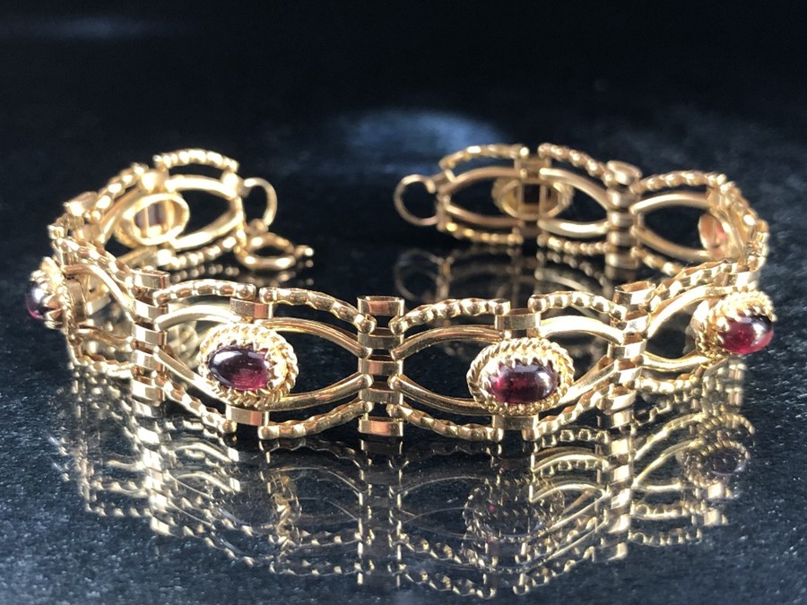 9ct Gold bracelet set with seven garnet oval stones (approx 9.5g)