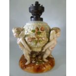 German porcelain table lamp, modelled on a flower encrusted basket supported by three cherubs,