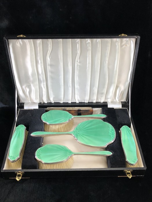 A silver and green enamel five piece dressing table set by Walker & Hall and a Silver hallmarked