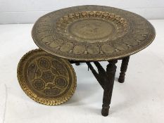 Indian Brass and Copper tea table with folding carved wooden legs and a second brass tray with