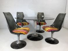 Oval glass topped retro dining table with four moulded retro chairs with striped upholstered seats