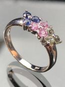 14k White gold ring set with nine small gems, 3 blue, 3 pink and 3 pale green stones, size approx