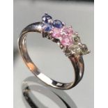 14k White gold ring set with nine small gems, 3 blue, 3 pink and 3 pale green stones, size approx